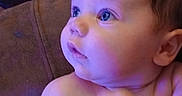 Wilson is registered to the contest to win money with this photo: adult_hand, baby, bare_chest, blue_lighting, child, close_up, couch, cuddling, curious, diaper, eyes, face, home, indoors, infant, photography, portrait, purple_lighting, seated, skin