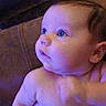 Wilson is registered to the contest to win money with this photo: baby, infant, child, portrait, close_up, face, eyes, curious, indoors, couch, seated, cuddling, adult_hand, diaper, bare_chest, skin, purple_lighting, blue_lighting, home, photography