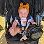 baby, child, stroller, headband, fan, foot, sunlight, outdoor, smiling, cute, clothing, playful, seatbelt, person, infant, summer, accessory, happy, black, orange