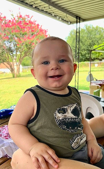 Nathaniel is registered to the contest to win money with this photo: baby, baby_toddler_clothing, child, event, facial_expression, fun, grass, hairstyle, happy, joy, leisure, people, person, plant, recreation, sitting, skin, smile, t_shirt, toddler