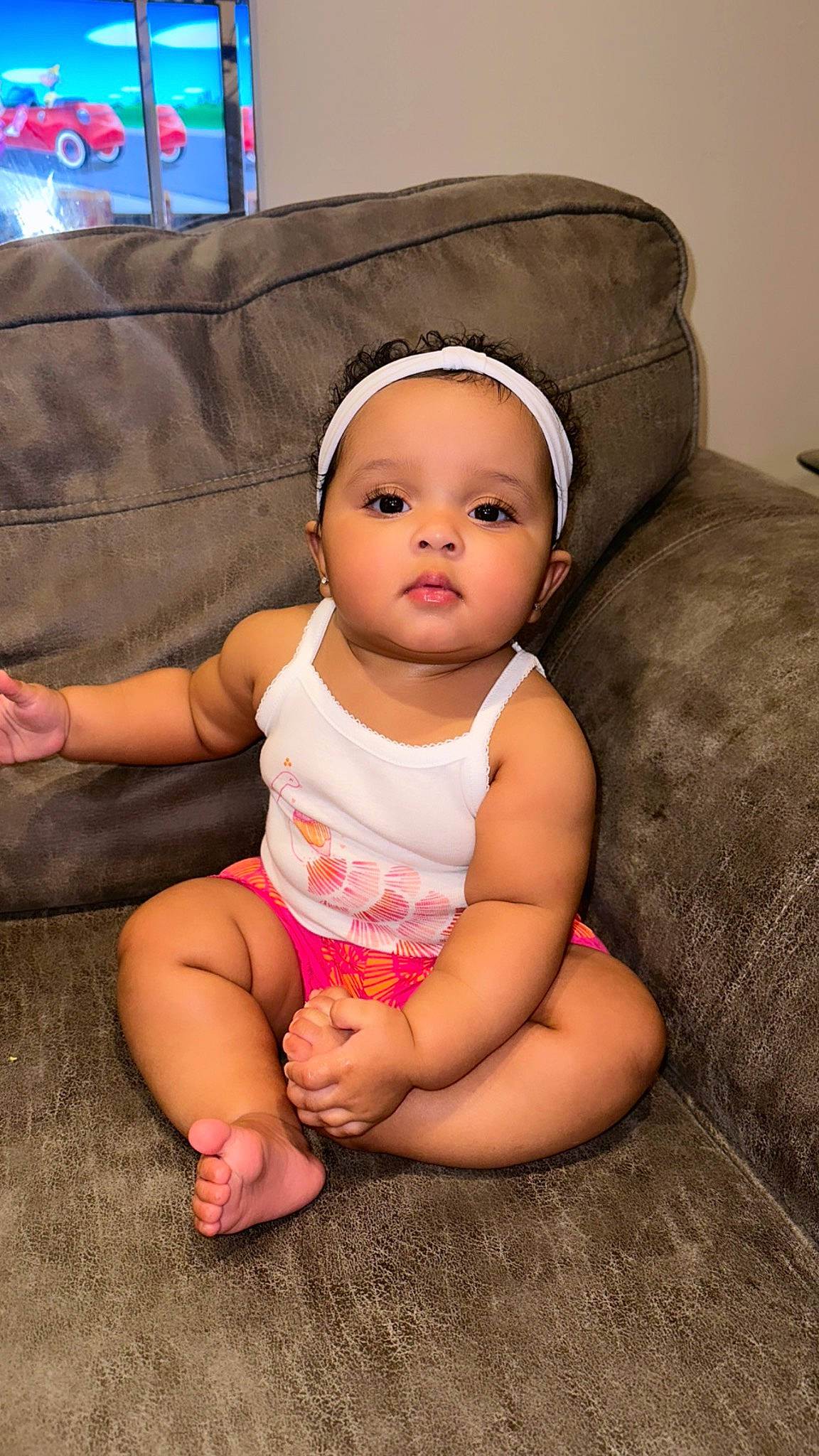 Zuri is registered to the contest to win money with this photo: baby, baby_toddler_clothing, cap, cheek, child, comfort, couch, face, finger, flash_photography, hand, happy, headgear, linens, lip, mouth, person, skin, smile, thumb