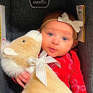 Abria joined the competition — help win amazing prizes! baby, child, stuffed_animal, car_seat, red_clothing, headband, bow, plush_toy, cute, infant, portrait, indoor, person, soft_toy, blue_eyes, cuddling, comfort, smiling, closeup, seat