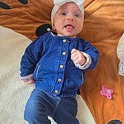 Rose a rejoint le concours — aidez-le/la à gagner de superbes lots ! baby, infant, headband, blue_jacket, blanket, pacifier, toy, playtime, cute, lying_down, indoors, child, face, expression, clothing, hand, footwear, fabric, comfort, smile