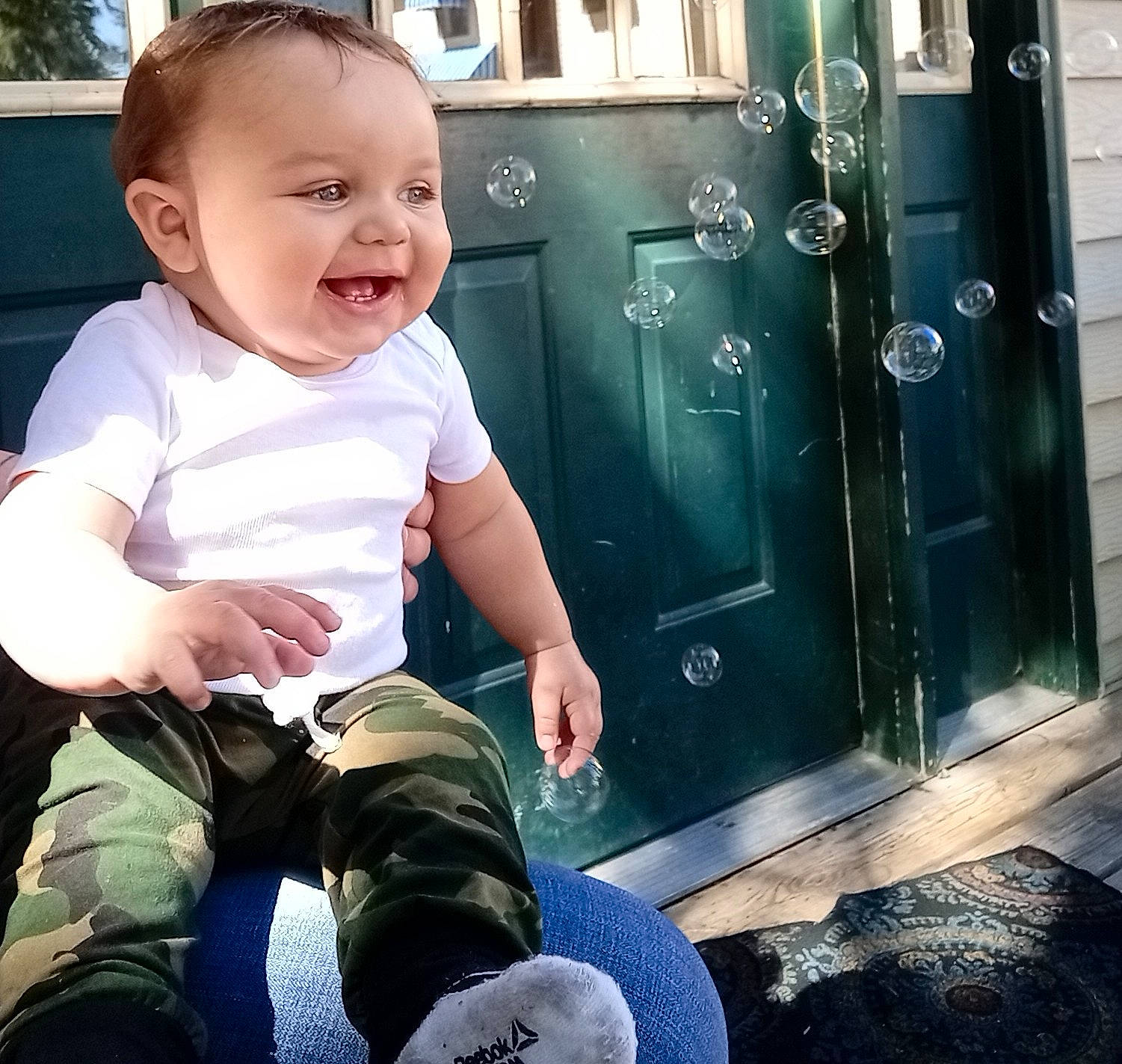 Dayton is registered to the contest to win money with this photo: baby, baby_toddler_clothing, child, cool, door, facial_expression, fun, hairstyle, happy, human_leg, joy, lap, metal, person, shoulder, sitting, sleeve, smile, standing, t_shirt