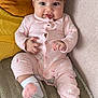 baby, child, infant, pink_pajamas, bunny_print, couch, pillow, soft_toys, sock, smile, face, hand, foot, cute, indoors, relaxed, seated, portrait, cozy, happy