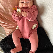 Lilyana participe au concours pour gagner de l'argent avec cette photo : baby, blanket, child, comfort, cozy, cute, face, feet, hands, happy, indoors, infant, lying_down, person, pillow, pink_outfit, portrait, smile, soft_texture, warm