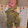 baby, infant, corduroy_overalls, lion_king, blanket, duck_pattern, hand, foot, face, sleepwear, person, cute, newborn, lying_down, indoors, soft_lighting, child, apparel, comfort, portrait