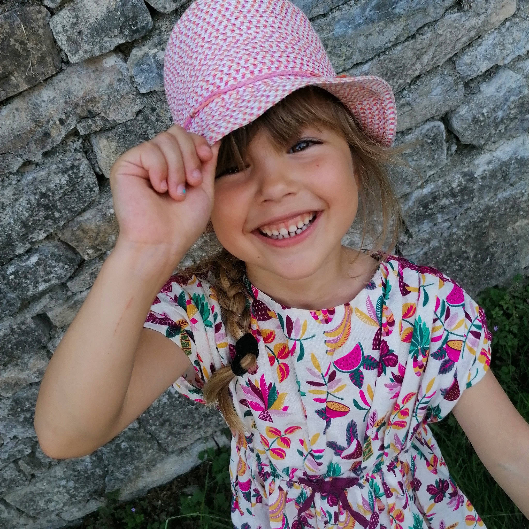 Capucine participe au concours pour gagner de l'argent avec cette photo : arm, cap, chin, clothing, facial_expression, gesture, grass, hand, happy, hat, headwear, joy, leaf, lip, organ, people_in_nature, person, photograph, pink, plant