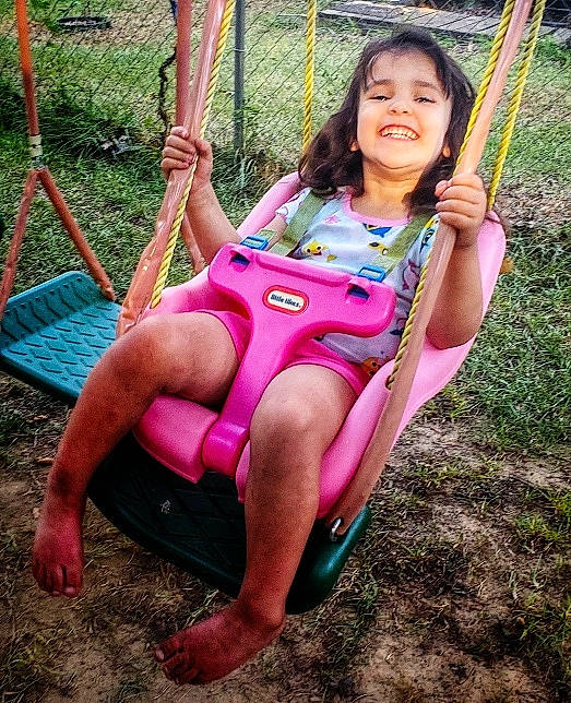 Kenzie joined the competition — help win amazing prizes! city, face, fun, grass, happy, head, human_leg, joy, leisure, magenta, outdoor_play_equipment, people_in_nature, person, pink, plant, playground, recreation, shorts, summer, swing