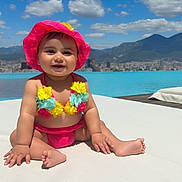 Nayla participe au concours pour gagner de l'argent avec cette photo : baby, child, bikini, pink_hat, flower_bikini, swimming_pool, outdoor, sunny, blue_sky, clouds, mountains, cityscape, happy, smiling, sitting, summer, vacation, water, skin, cute