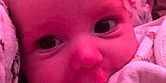 Finley is registered to the contest to win money with this photo: baby, close_up, face, infant, blanket, soft, cute, eyes, skin, hand, clothing, portrait, indoors, toddler, newborn, expression, warm, pink_tint, cozy, child