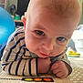 Finley is registered to the contest to win money with this photo: baby, child, tummy, striped_clothing, indoor, exercise_ball, floor_mat, closeup, curious, playful, person, infant, head, hands, eyes, home, light, blurred_background, toy, candid