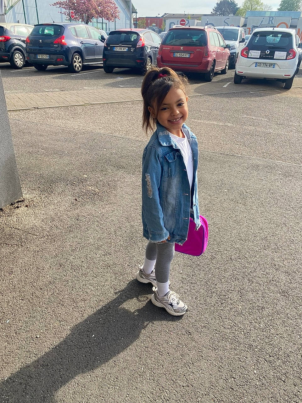 Hina participe au concours pour gagner de l'argent avec cette photo : asphalt, automotive_tire, car, grass, jeans, joy, motor_vehicle, person, plant, public_space, road, road_surface, sidewalk, sneakers, tints_and_shades, tire, toddler, tree, vehicle, vehicle_door