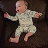 baby, infant, child, pajamas, laughing, happy, smiling, couch, leather, furniture, indoors, person, cute, small, feet, hands, face, sitting, cozy, relaxed