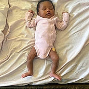 Dakota is registered to the contest to win money with this photo: baby, sleeping, infant, pink_onesie, bed, white_sheet, relaxed, arms_up, feet, bandage, indoors, person, child, newborn, curly_hair, sleep, resting, blanket, cotton, peaceful