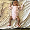 baby, sleeping, infant, pink_onesie, bed, white_sheet, relaxed, arms_up, feet, bandage, indoors, person, child, newborn, curly_hair, sleep, resting, blanket, cotton, peaceful