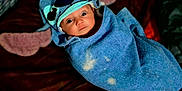 Zoey is registered to the contest to win money with this photo: baby, child, towel, hood, face, wrapped, blue_towel, wide_eyes, curious, indoor, blanket, soft, lying_down, person, cute, portrait, infant, cozy, expression, young