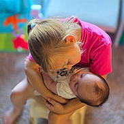 Zoey is registered to the contest to win money with this photo: child, baby, holding, love, affection, pink_shirt, sleeping, toddler, indoor, blurry_background, hair_tie, face, arm, cute, family, bond, closeup, portrait, person, caring