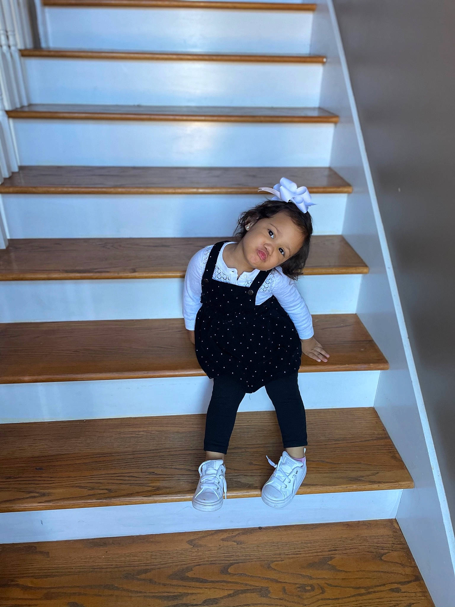 Iliana is registered to the contest to win money with this photo: child_model, foot, handrail, person, photo_shoot, stairs, sweatpant, wood_flooring, wood_stain