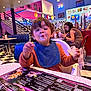 toddler, child, bib, food, messy_face, diner, retro, neon_lights, menu, table, chair, blue_chair, checkered_floor, woman, glasses, people, indoor, casual_clothing, eating, high_chair