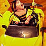 baby, child, costume, bumblebee, toy_car, lamborghini, yellow, indoor, floor, headband, happy, smiling, hands, seat, vehicle, flooring, decorations, face, person, cute