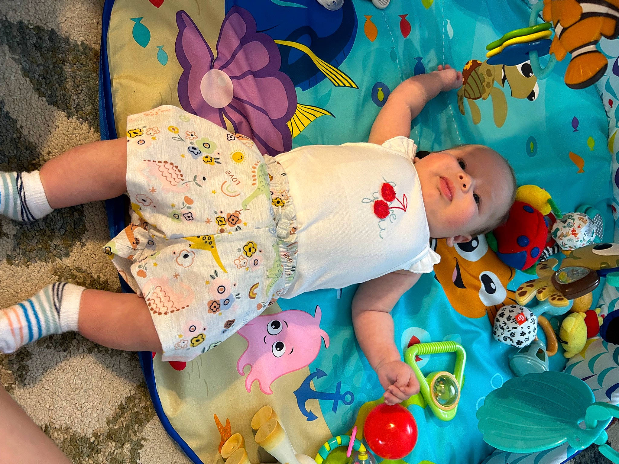Skyler is registered to the contest to win money with this photo: baby, baby_products, baby_toddler_clothing, baby_toys, child, foot, fun, happy, human_leg, leisure, linens, pattern, person, pink, play, room, summer, textile, toddler, toy