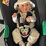 Giulia a rejoint le concours — aidez-le/la à gagner de superbes lots ! baby, baby_hat, black_car_seat, car_seat, child, curious, cute, floor, green_accent, hat, infant, infant_clothing, newborn, outdoor, safety_harness, seatbelt, small_hands, socks, white_clothing, wide_eyes