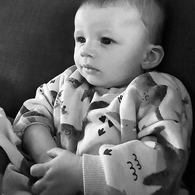 Ezra is registered to the contest to win money with this photo: arm, baby, babylaughing, blanket, blonde, bodypart, clothing, face, finger, hair, hand, happy, head, mohawkhairstyle, newborn, pajamas, person, photography, portrait, sitting