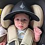 baby, infant, car_seat, hat, cap, face, tongue, wide_eyes, straps, beige, black, clothing, child, cute, portrait, person, seatbelt, safety, expression, indoors