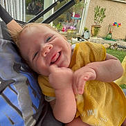 Arthur a rejoint le concours — aidez-le/la à gagner de superbes lots ! baby, smiling, yellow_bib, person, arm, outdoor, garden, plants, window, wall, colorful, decoration, happy, tongue_out, casual_clothing, close_up, daylight, skin, infant, holding