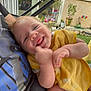 baby, smiling, yellow_bib, person, arm, outdoor, garden, plants, window, wall, colorful, decoration, happy, tongue_out, casual_clothing, close_up, daylight, skin, infant, holding