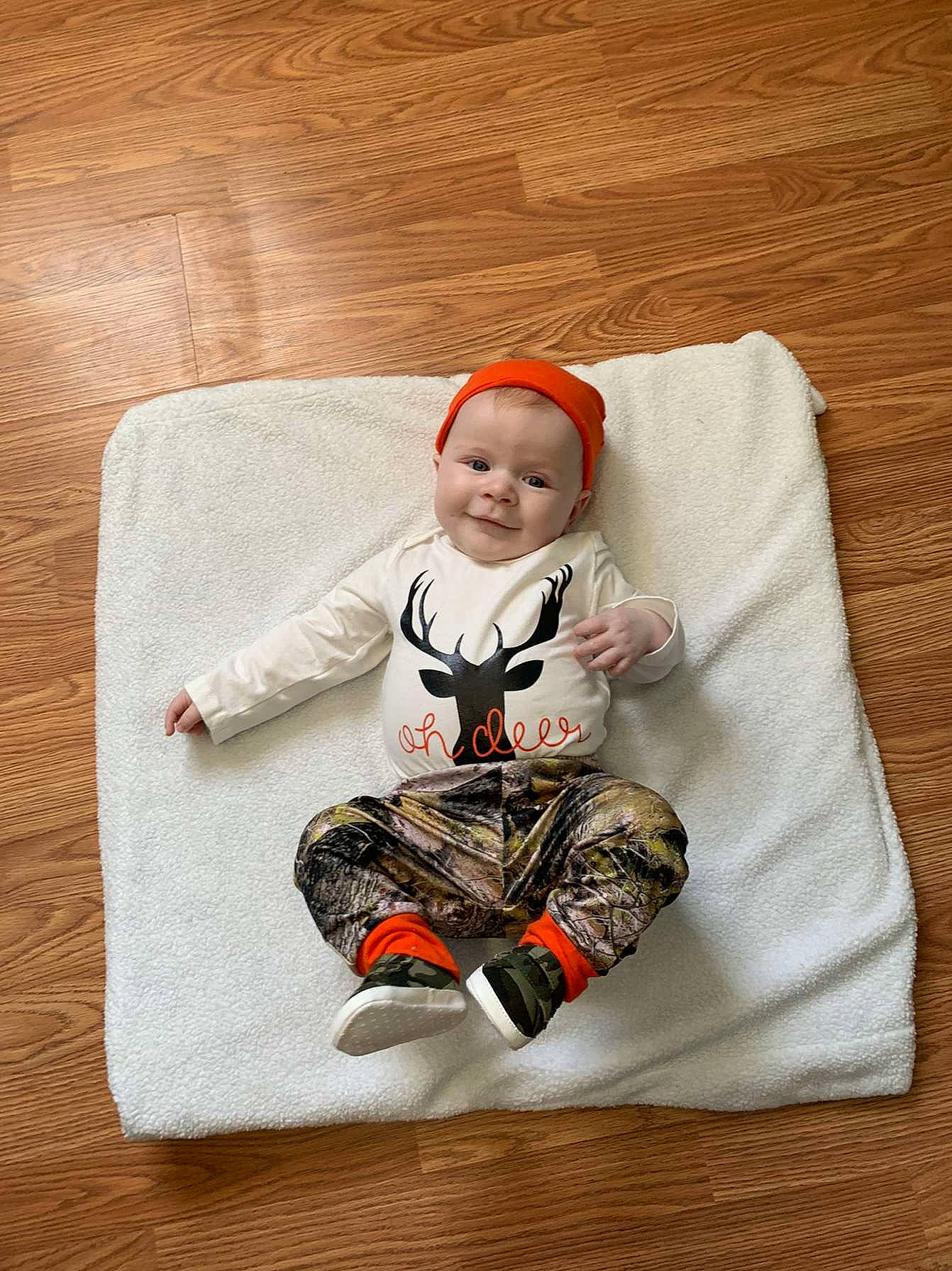 Cole is registered to the contest to win money with this photo: baby, baby_toddler_clothing, carmine, christmas, comfort, costume_hat, doll, face, fictional_character, flooring, hardwood, head, joy, long_sleeved_t_shirt, pattern, person, play, sitting, sleeve, t_shirt