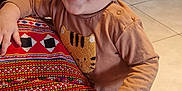 Thélyo participe au concours pour gagner de l'argent avec cette photo : toddler, child, smiling, happy, indoor, couch, patterned_fabric, red_purse, hand, clothing, table, chair, floor, person, face, young_child, home, furniture, casual, cute