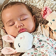 Syana participe au concours pour gagner de l'argent avec cette photo : baby, blanket, bunny, child, close_up, comfort, cozy, cute, face, floral_pattern, indoors, infant, nap, pajamas, peaceful, plush_toy, portrait, resting, sleeping, soft_toy