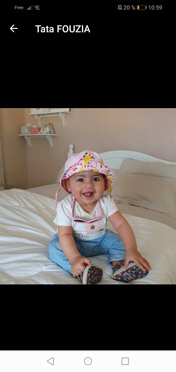 Sana participe au concours pour gagner de l'argent avec cette photo : baby, baby_toddler_clothing, bonnet, cap, child, ear, fashion_accessory, fun, hair_accessory, happy, headgear, headwear, joy, person, photography, play, sitting, skin, smile, snapshot