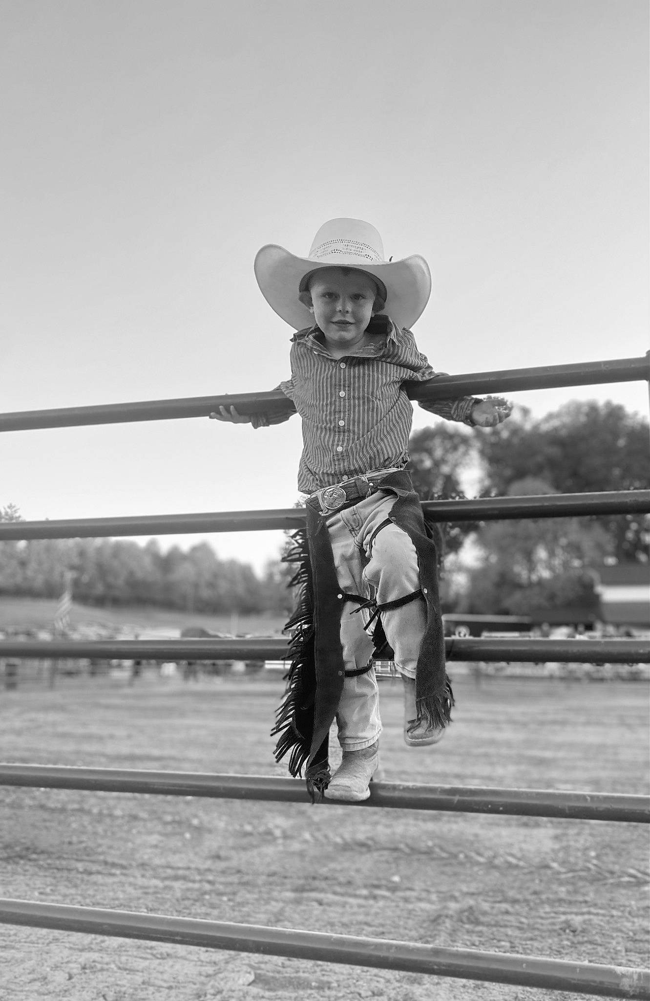 Jackson James is registered to the contest to win money with this photo: black_and_white, child, cowboy_hat, fashion_accessory, flash_photography, fun, gesture, happy, hat, human_leg, landscape, monochrome, monochrome_photography, people_in_nature, person, sky, smile, sun_hat, toddler, travel