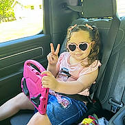 Ediatny joined the competition — help win amazing prizes! child, girl, sunglasses, heart_shaped, tablet, car_seat, seatbelt, pink, peace_sign, clothing, denim_skirt, hair_bows, window, blanket, interior, vehicle, summer, casual, playful, happy