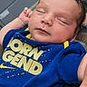 Oakley is registered to the contest to win money with this photo: baby, newborn, sleeping, blue_clothing, onesie, infant, face, peaceful, closeup, child, person, skin, hand, resting, young, cute, portrait, soft_light, yellow_text, casual