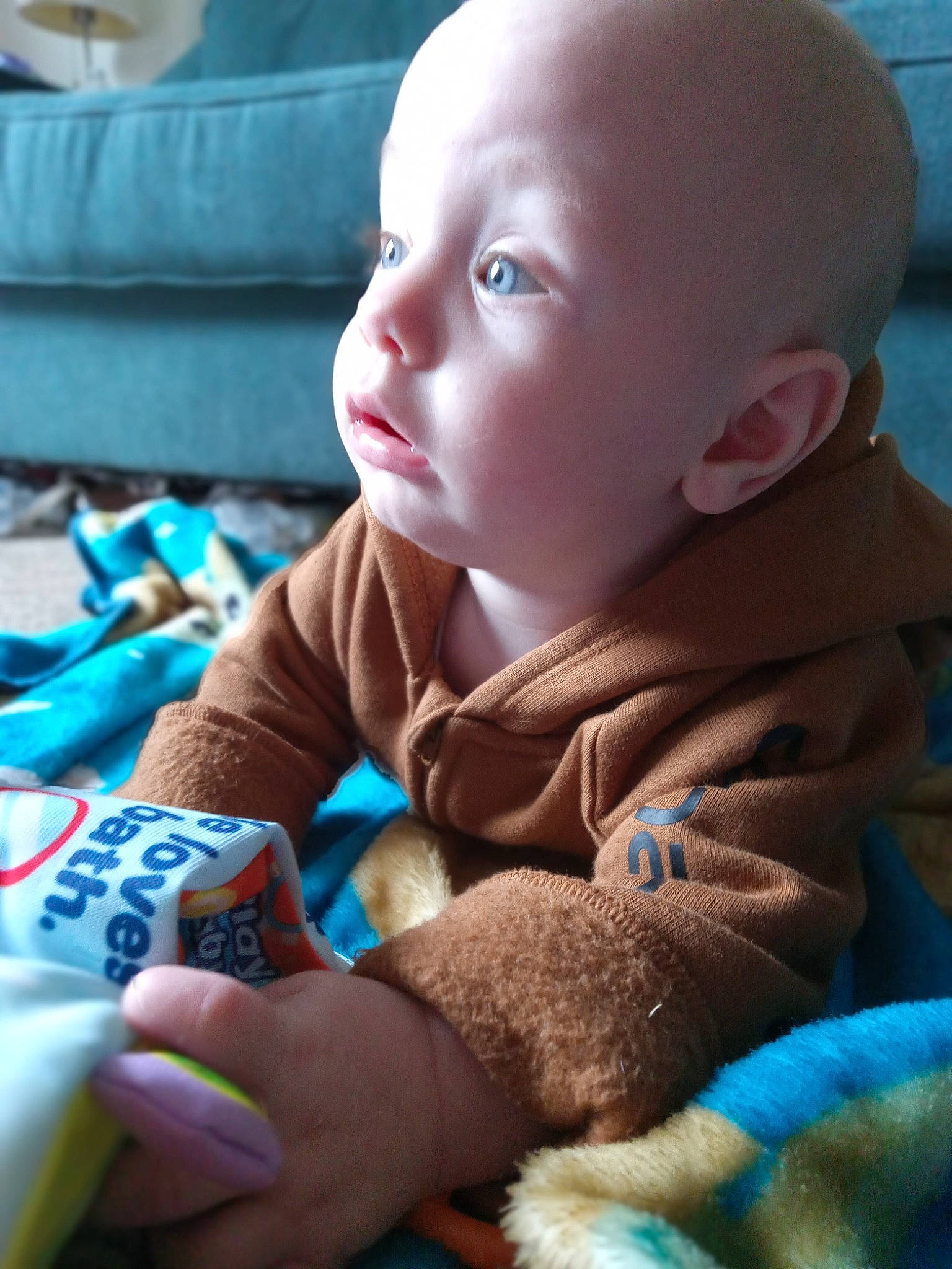 Tobias is registered to the contest to win money with this photo: baby, baby_products, baby_toddler_clothing, blue, cheek, child, comfort, finger, flooring, fun, hand, happy, iris, person, play, product, sitting, skin, textile, toddler