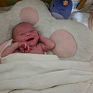 Reagan Tigerlily joined the competition — help win amazing prizes! baby, blanket, pillow, plush_toy, smile, happy, infant, bed, soft_texture, cute, cozy, child, sleeping_area, pink, purple, flower, wooden_bed, comfort, wrapped, portrait