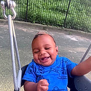 Zahir joined the competition — help win amazing prizes! baby, blue_shirt, casual_clothing, child, cute, daytime, fence, fun, greenery, happy, infant, joyful, metal_chain, outdoor, park, person, playground, seat, smiling, swing