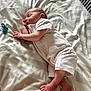 baby, newborn, sleeping, bed, blanket, pacifier, infant, clothing, foot, hand, face, skin, lying_down, cozy, soft, rest, cute, peaceful, indoors, natural_light