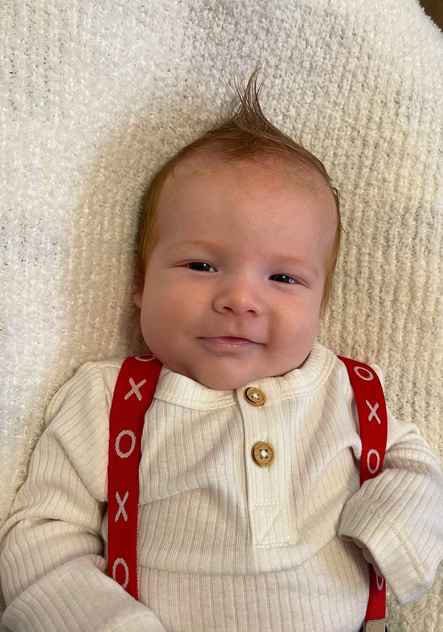 Sutton is registered to the contest to win money with this photo: baby, baby_toddler_clothing, brown_hair, cheek, clothing, collar, eye, eyelash, happy, iris, joy, lip, nose, outerwear, pattern, person, sitting, skin, sleeve, smile