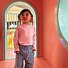 Jade participe au concours pour gagner de l'argent avec cette photo : child, girl, pigtails, pink_shirt, blue_jeans, standing, indoor, arched_doorway, window, curious, portrait, colorful, casual_clothing, young, fashion, cute, expression, playful, light, room