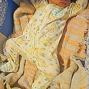 Julian is registered to the contest to win money with this photo: baby, sleeping, onesie, blanket, crib, bassinet, infant, cozy, patterned, animal_print, child, peaceful, resting, soft, fabric, cute, young, indoors, comfort, wearing