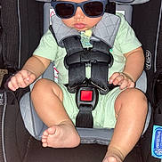 Julian is registered to the contest to win money with this photo: baby, sunglasses, car_seat, child, infant, safety_harness, cute, clothing, foot, hand, seat, indoor, person, toddler, head, eyewear, resting, infant_clothing, baby_seat, strap