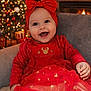 baby, child, smiling, red_dress, headband, bow, christmas_tree, holiday, festive, indoor, cozy, chair, decorations, happy, cute, portrait, sparkle, celebration, mickey_mouse, warm_lighting