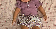 Kaylee joined the competition — help win amazing prizes! baby, blanket, bow, child, clothing, cute, face, floral_pattern, hands, happy, indoors, infant, legs, lying_down, person, portrait, purple_clothing, skin, small_child, smiling