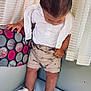 toddler, child, white_shoes, patterned_shorts, white_shirt, standing, indoor, curtains, cushion, soft_surface, looking_down, short_hair, clothing, footwear, hand, wall, fabric, home, cute, exploration