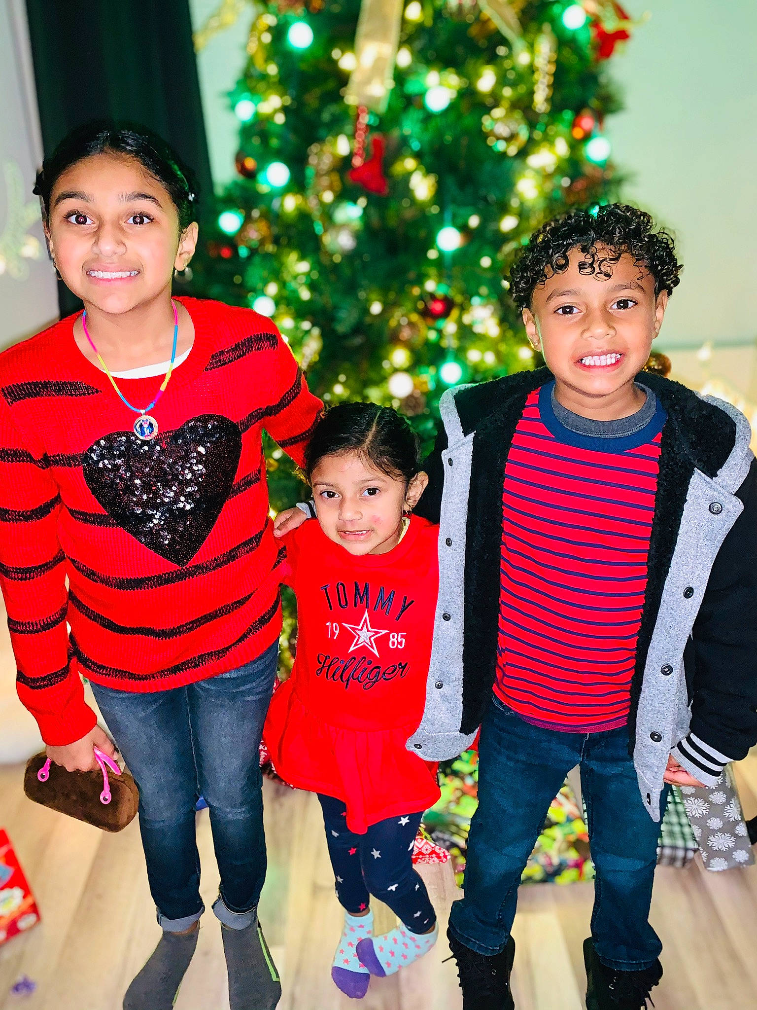 Chloe is registered to the contest to win money with this photo: child, christmas, christmas_decoration, christmas_eve, christmas_tree, daughter, event, family, happy, holiday, joy, outerwear, people, person, sibling, smile, standing, sweater, toddler, tree